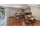A well-lit dining room with wood floors, an elegant dining table, and a sliding glass door that leads to the backyard at 455 Greenwood, Longmont, CO 80504