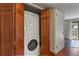 Laundry closet with wood-stained folding doors featuring stacked washer and dryer units next to a doorway at 455 Greenwood, Longmont, CO 80504