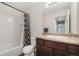 Bathroom features vanity, toilet, mirror, and shower-tub combination with a floral curtain at 47341 Lily Ave, Bennett, CO 80102