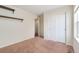 Bedroom features neutral walls, a carpeted floor, two shelves, and a closet with white sliding doors at 47341 Lily Ave, Bennett, CO 80102