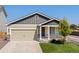 Charming home featuring a gray and light green exterior, two-car garage and a well-maintained lawn at 47341 Lily Ave, Bennett, CO 80102