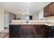 A kitchen featuring dark cabinets, stainless steel sink, and a view into the living space at 47341 Lily Ave, Bennett, CO 80102