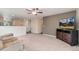 Spacious living room featuring carpet floors, TV, and easy access to kitchen at 47341 Lily Ave, Bennett, CO 80102