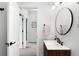 Modern bathroom featuring a round mirror, wood vanity, and neutral walls at 6780 Meade Cir # B, Westminster, CO 80030