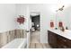 Modern bathroom featuring a soaking tub, wood vanity, and neutral tilework at 6780 Meade Cir # B, Westminster, CO 80030