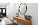 Bright entryway with a wood console table and a large round mirror at 6780 Meade Cir # B, Westminster, CO 80030