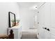 Upstairs hallway with white walls, doors, trim and hallway table with mirror at 6780 Meade Cir # B, Westminster, CO 80030