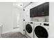 Well-organized laundry room with modern appliances and black cabinets at 6780 Meade Cir # B, Westminster, CO 80030