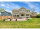 Backyard featuring an expansive patio, green lawn, wooden fence, and the home's exterior at 6769 W 70Th Ave, Arvada, CO 80003