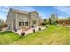Backyard with patio, a green lawn, and mature landscaping with the home's exterior and blue planters at 6769 W 70Th Ave, Arvada, CO 80003