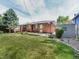 Expansive backyard with lush lawn, mature trees, a storage shed, and inviting patio area at 6769 W 70Th Ave, Arvada, CO 80003