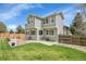 Backyard featuring a patio, lush lawn, wooden fence, mature trees, and views of the home's exterior at 6769 W 70Th Ave, Arvada, CO 80003