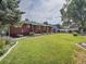 Large backyard offering an expansive lawn, mature trees, and well-maintained landscaping at 6769 W 70Th Ave, Arvada, CO 80003