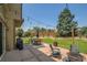 Spacious backyard features a patio with dining area, grill, and comfortable seating, landscaping and string lights at 6769 W 70Th Ave, Arvada, CO 80003