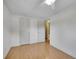 Bright bedroom features wood floors, white walls, ceiling fan, and access to an ensuite bathroom and closet at 6769 W 70Th Ave, Arvada, CO 80003