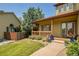 Charming front porch with wooden railings and posts, accented with lovely landscaping and flowering plants at 6769 W 70Th Ave, Arvada, CO 80003