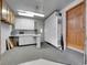 Well-organized garage with built-in white storage, countertops, and utility sink, and a practical entrance door at 6769 W 70Th Ave, Arvada, CO 80003
