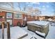 Hot tub and partially snow-covered backyard with brick house at 3345 W Aqueduct Ave, Littleton, CO 80123