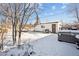 Detached garage and snow-covered backyard with hot tub at 3345 W Aqueduct Ave, Littleton, CO 80123