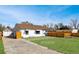 Charming exterior showing a well-maintained lawn, a wooden fence, and a detached garage at 2829 W College Ave, Denver, CO 80219
