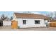 Exterior view of home with white siding, awning covered windows, privacy fence and brown shingled roof at 2829 W College Ave, Denver, CO 80219