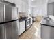 Well-lit kitchen with tile flooring, stainless steel fridge, and white cabinets at 2829 W College Ave, Denver, CO 80219