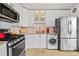View of kitchen featuring modern white cabinets, stainless steel appliances, granite countertops, and in-unit washer at 800 N Washington St # 710, Denver, CO 80203
