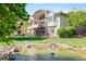 Stunning backyard with a pond, fountain, mature trees, and an exterior staircase at 12 Canon Cir, Greenwood Village, CO 80111