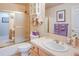 Bright bathroom featuring a shower-tub combo, tiled countertop with an oval sink, and storage cabinet at 12 Canon Cir, Greenwood Village, CO 80111