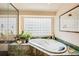 Serene bathroom with soaking tub, glass block window, and green marble accents at 12 Canon Cir, Greenwood Village, CO 80111