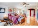 Bright bedroom features hardwood floors, a sitting area near the window, and a cozy, striped bed with decorative pillows at 12 Canon Cir, Greenwood Village, CO 80111