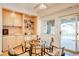 Bright dining area with a glass table, modern chairs, built-in shelving and cabinetry, and outdoor access at 12 Canon Cir, Greenwood Village, CO 80111