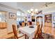 Open-concept dining room with vaulted ceilings, chandelier and hardwood floors leading to the living room and kitchen at 12 Canon Cir, Greenwood Village, CO 80111