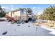 Backyard featuring a stucco and stone exterior with a spiral staircase and snow-covered ground at 12 Canon Cir, Greenwood Village, CO 80111