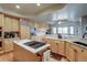 Spacious kitchen with wood cabinets, marble countertops, an island cooktop, and stainless steel appliances at 12 Canon Cir, Greenwood Village, CO 80111