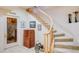 Charming staircase with a wooden railing leading to a 'Got Wine' wine cellar, accented by artwork and a decorative bicycle at 12 Canon Cir, Greenwood Village, CO 80111