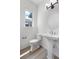 Clean bathroom with a pedestal sink, white toilet, and a window with natural light at 2347 Kite Route Ln, Superior, CO 80027