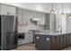 Modern kitchen featuring gray cabinetry, stainless steel appliances, and a spacious island at 2347 Kite Route Ln, Superior, CO 80027