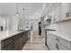 Open kitchen with gray cabinets, stainless steel appliances, and an island with bar seating at 2347 Kite Route Ln, Superior, CO 80027