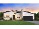 Modern exterior featuring a stone chimney, black garage door, and sleek architectural details at 12614 E Fremont Dr, Littleton, CO 80127