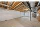Unfinished basement with exposed ceiling, concrete floors, and white plastic-wrapped walls at 7306 Watercress Dr, Littleton, CO 80125