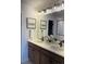 Bathroom features a dual sink vanity with modern fixtures and framed mirrors at 7306 Watercress Dr, Littleton, CO 80125