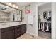 Bathroom featuring double sinks, modern lighting, and access to walk-in closet at 16486 W 94Th Dr, Arvada, CO 80007