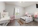 Bright bedroom featuring a vanity, stylish decor, and plenty of natural light from the window at 16486 W 94Th Dr, Arvada, CO 80007