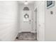 Bright entryway featuring a white door with decorative wreath, wood-look flooring and shiplap accent wall at 16486 W 94Th Dr, Arvada, CO 80007