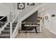 Bright entryway featuring a staircase with white and black railings, wood flooring, and stylish decor at 16486 W 94Th Dr, Arvada, CO 80007