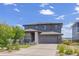 Two-story home with gray siding, attached two car garage, and a well manicured lawn and landscaping at 16486 W 94Th Dr, Arvada, CO 80007