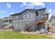 Exterior view of the back of the home featuring a patio, deck and spacious backyard at 16486 W 94Th Dr, Arvada, CO 80007
