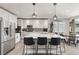 Bright kitchen featuring white cabinetry, a large center island, pendant lighting and stainless appliances at 16486 W 94Th Dr, Arvada, CO 80007