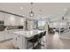 Open-concept kitchen with white cabinets, a large center island, pendant lighting, and modern stainless appliances at 16486 W 94Th Dr, Arvada, CO 80007